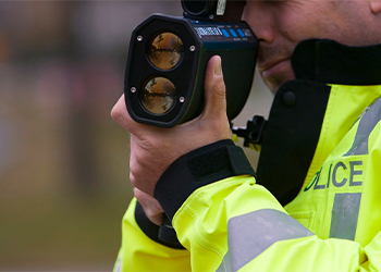 Police measuring speed using speed gun