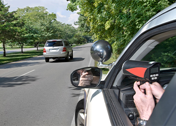 Police measuring speed of car using speed gun