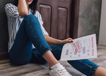 Sad women sitting in floor holding foreclosure notice
