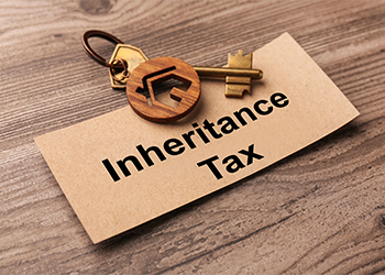 House shaped keychain, key and paper with word Inheritance Tax