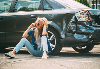 Girl sits on the road, near the broken car and calls on the phone