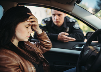 Sad female driver after being pulled over for traffic violation