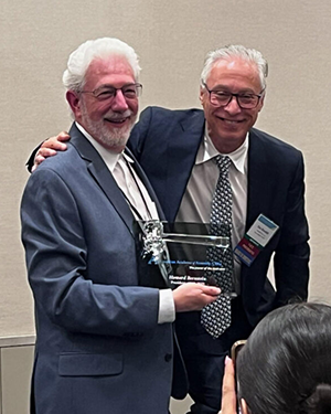 Howard receiving a plaque for his service as President of the AAA-CPA