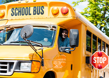 Driver looking through window of a school bus