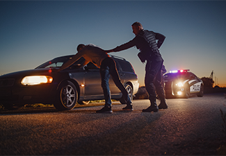 A Professional Middle Aged Policeman Performing a Pat-Down Search
