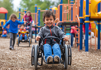 Child in wheel chair with a disability playing on an accessible playground