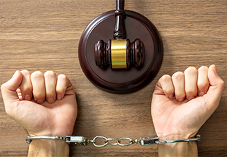 Handcuff locked and judge gavel on table