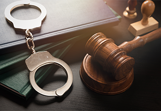 Metal handcuffs near judge gavel