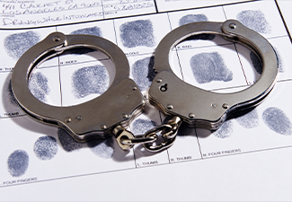 Handcuffs laying on top of fingerprint chart