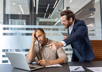 Manager shouting at frustrated employee in office