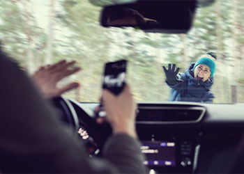 Driver with phone in hand about to hit a pedestrian