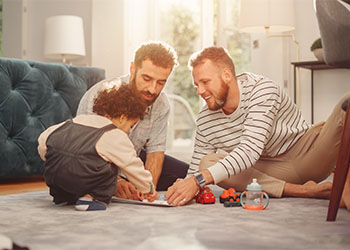 Cheerful Gay Couple looking after a Child