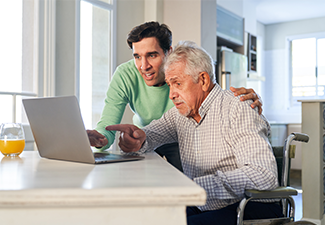 Senior person using computer with help