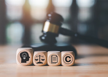 Gavel and wooden blocks with icons related to intellectual property