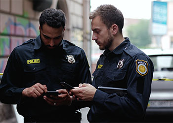 Policemen searching for evidence in mobile phone of accused person
