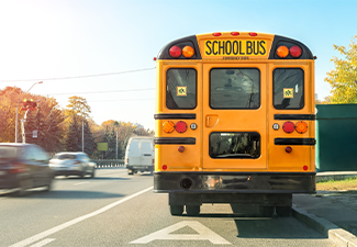 American yellow schoolbus standing on a bus lane at highway