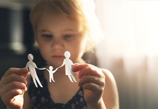 Little girl with paper family in hands