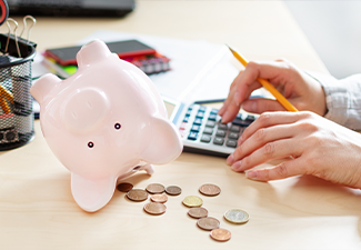 Women counting coins on calculator taking from the piggy bank