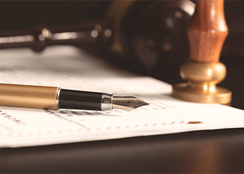 Will document with pen, notary stamp and gavel on table