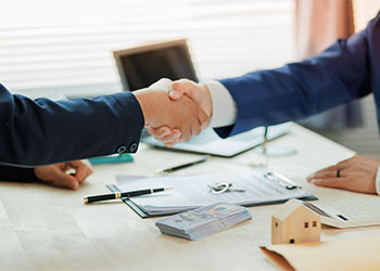 Client shaking hand with real estate agent after successful agreement