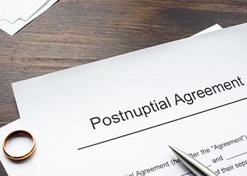Postnuptial agreement form, ring and pen on table