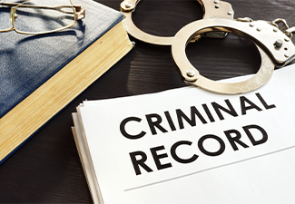 Criminal record and handcuffs on a desk