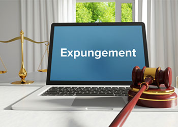 Expungement word on laptop screen with gavel and scale of justice
