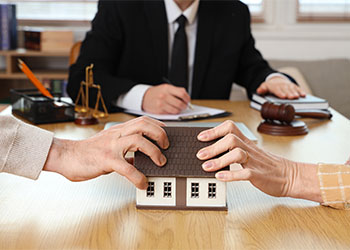 Couples holding into house model during divorce