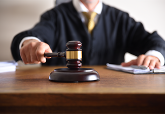 Judge passing sentence by hitting with gavel closeup