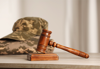 Gavel and military uniform on wooden table