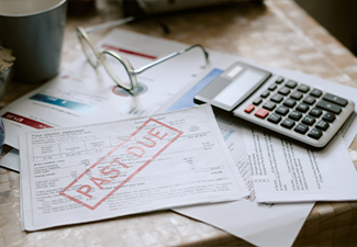 Overdue utility bills, documents marked past due on table