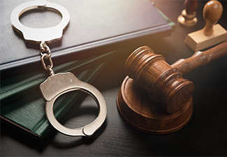 Metal handcuffs near judge gavel