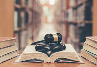 Old book in library with judge gavel on open law textbook in court