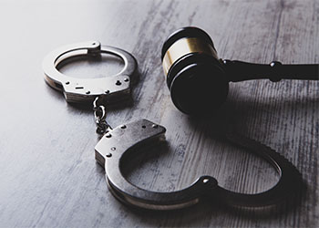 Handcuff and gavel on table