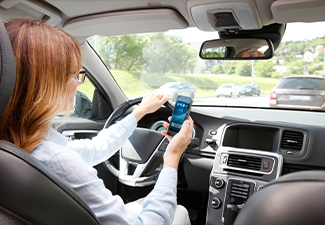 Woman using handy in her car while driving