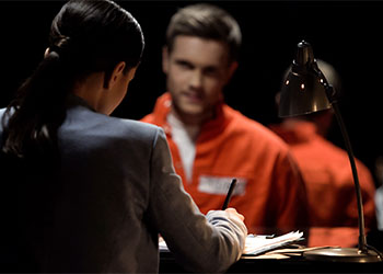 Criminal defense attorney with accused prisoner preparing statements