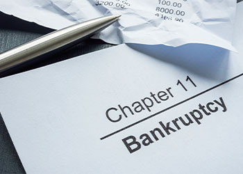 Chapter 11 bankruptcy paper and pen in table