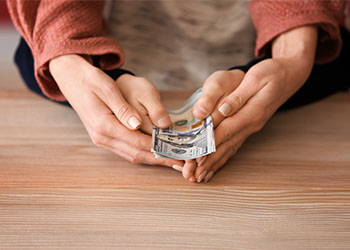 Hands of mother and child holding dollar bills