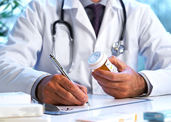 Doctor writing out prescription drugs