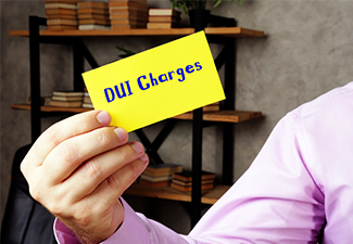 Man holding DUI Charges sign on the piece of paper