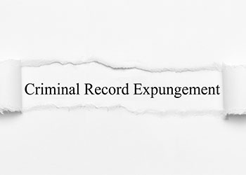 Criminal Record Expungement word on white torn paper