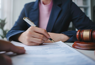 Lawyer is signing a last will and testament during a meeting with a client