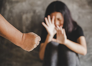 Closed fist of man and women crying in background