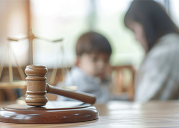 Gavel on table with mother and child in background