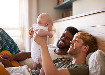 Loving Male Same Sex Couple Cuddling Baby Daughter
