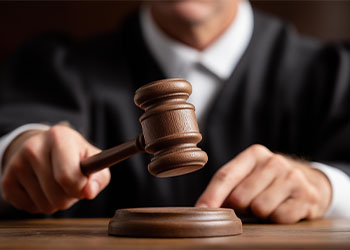 Faceless judge striking gavel in courtroom