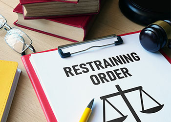 Restraining Order file and gavel on table