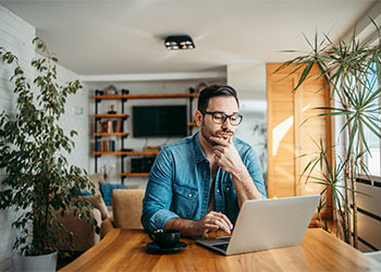Man thinking while looking at Laptop
