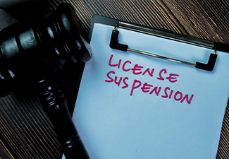 Concept of License Suspension write on paperwork with gavel isolated on Wooden Table