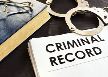 Criminal record file and handcuffs on a desk